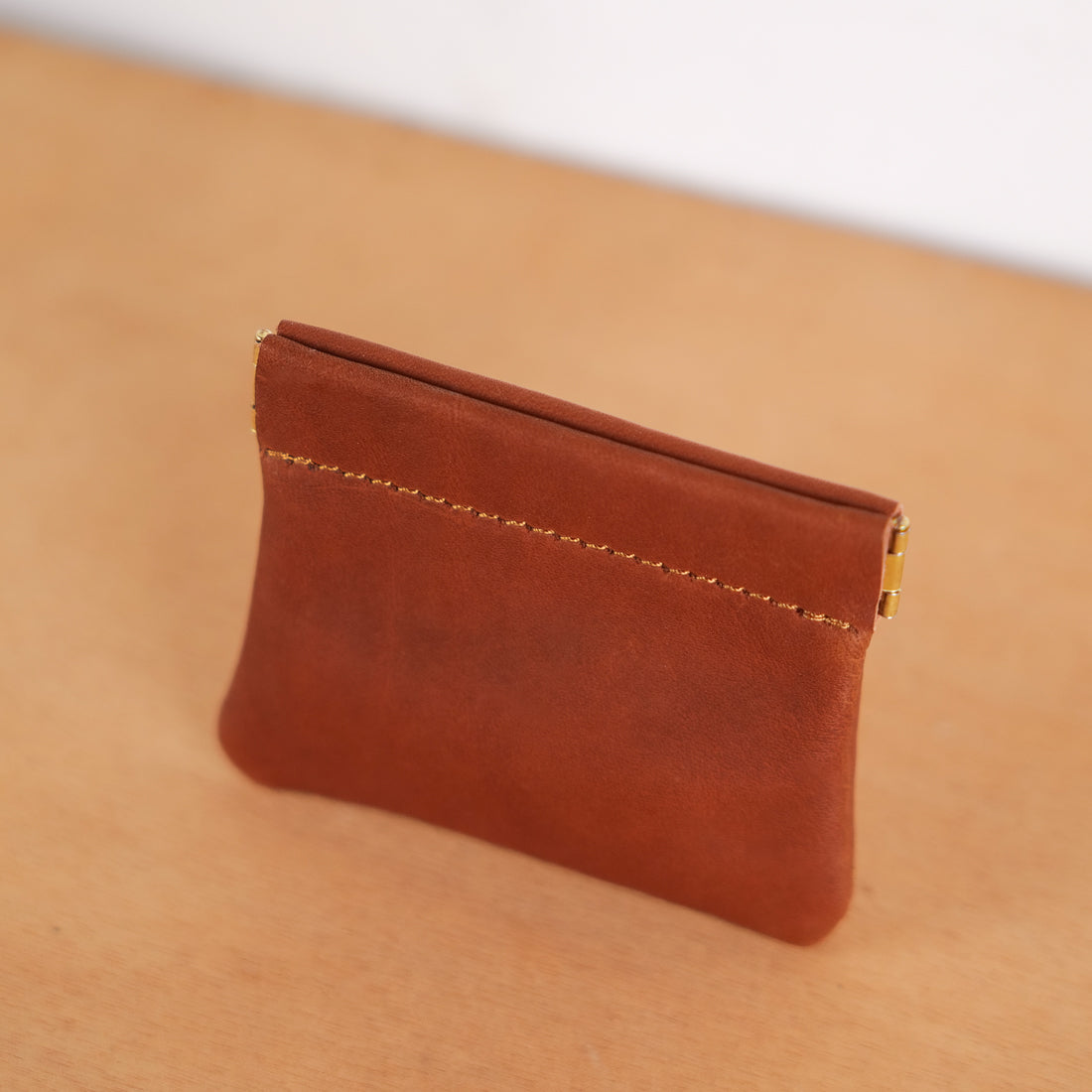 Tan leather kiss-lock coin purse