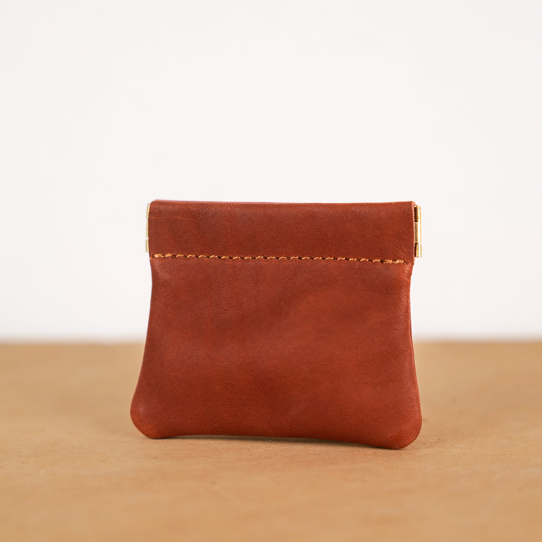 Tan leather kiss-lock coin purse