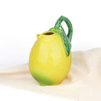 Carafe Bordallo Pinheiro sur une nappe blanche, lumière naturelle
