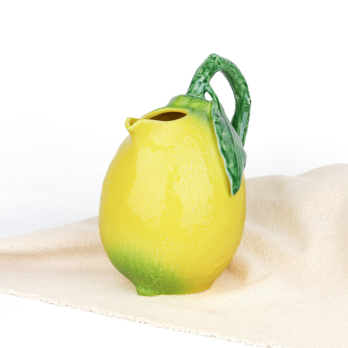 Carafe Bordallo Pinheiro sur une nappe blanche, lumière naturelle