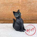 Chat noir qui hoche la tête