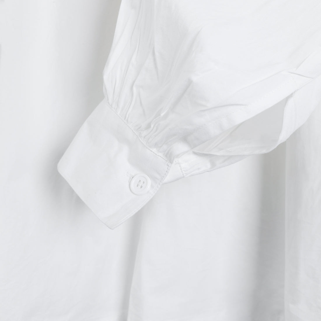Buttoned cuff detail on the white Picasso shirt by Coline Diffusion, gathered sleeve