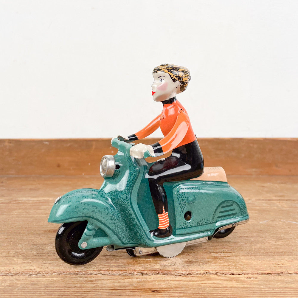 Fille en scooter vert mécanique