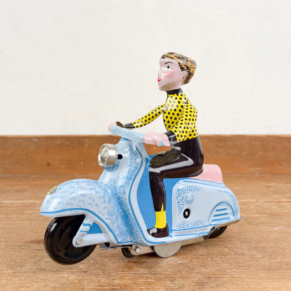 Fille en scooter bleu mécanique