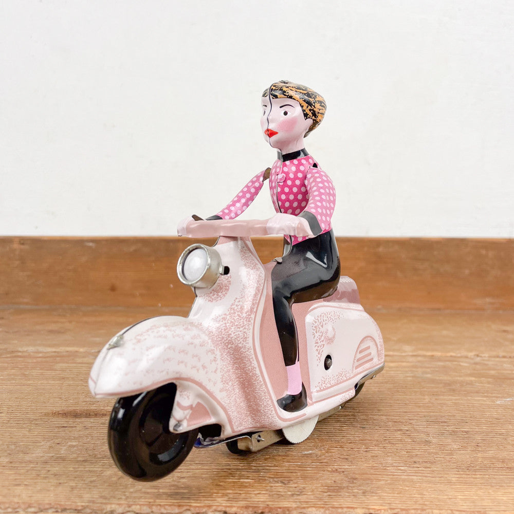 Fille en scooter rose mécanique