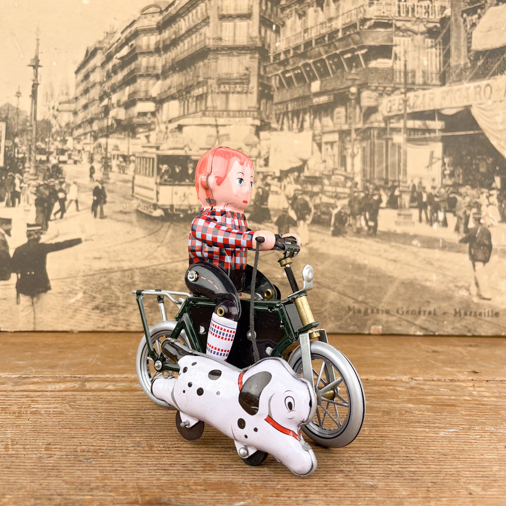 Garçon à bicyclette mécanique avec chien