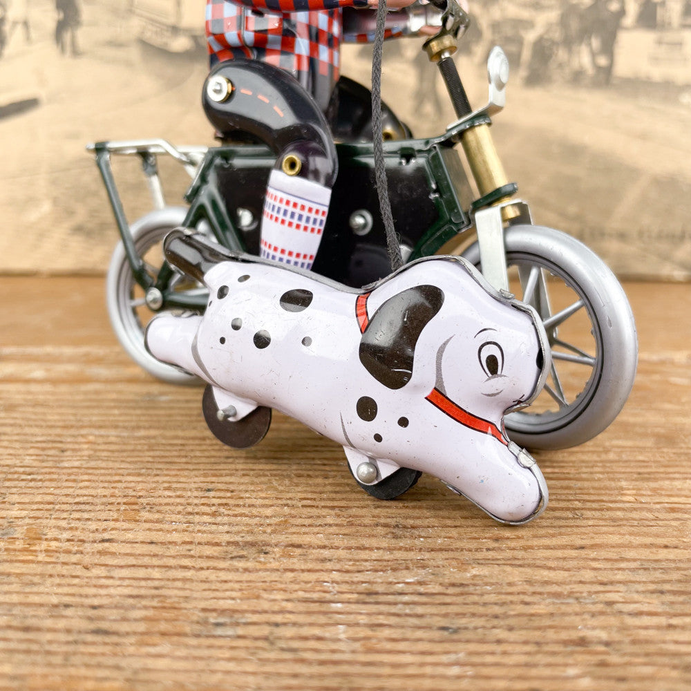 Garçon à bicyclette mécanique avec chien