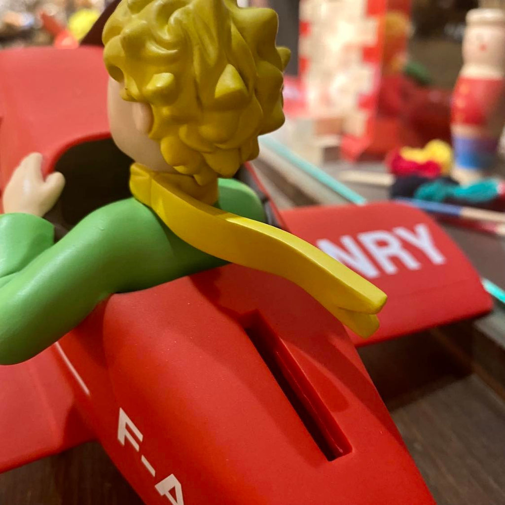 Tirelire le Petit Prince dans son avion