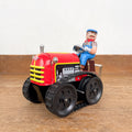 Tracteur mécanique rouge et son chauffeur